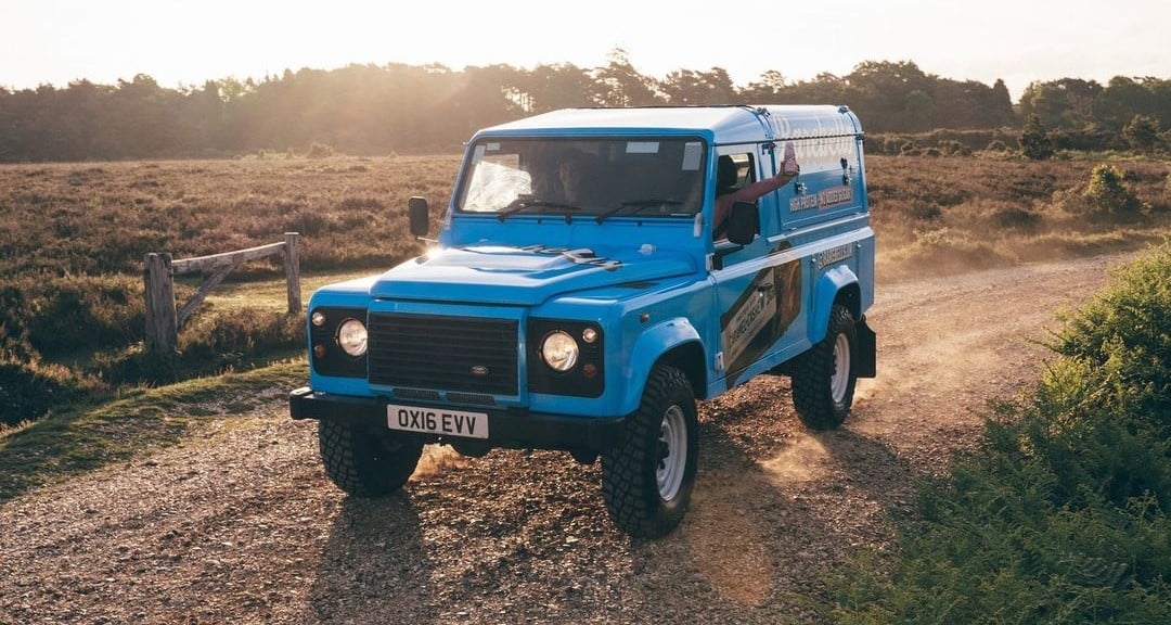 Blue Barebells Land Rover Defender on country road